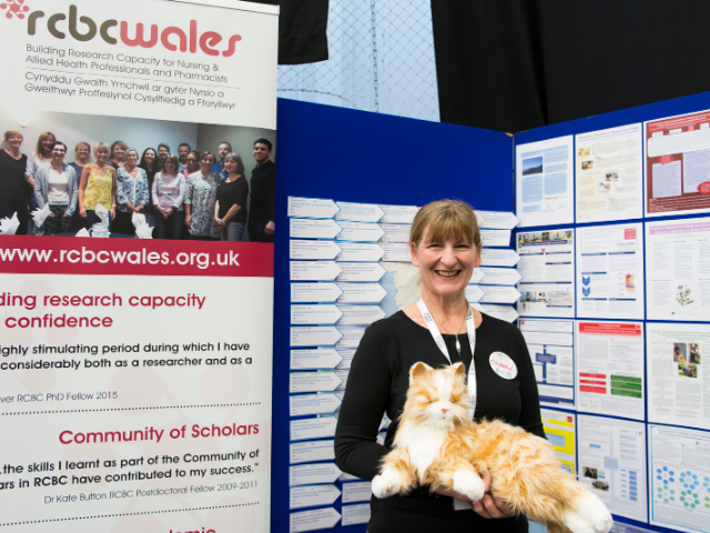 Woman with toy cat at exhibition stand