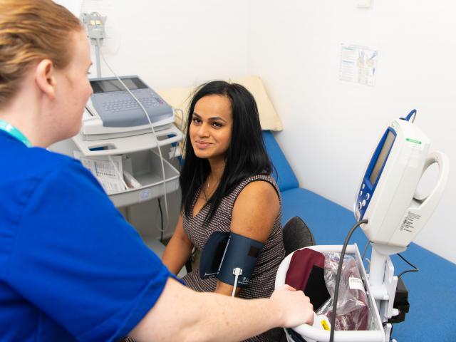 Nurse taking the blood pressure of woman