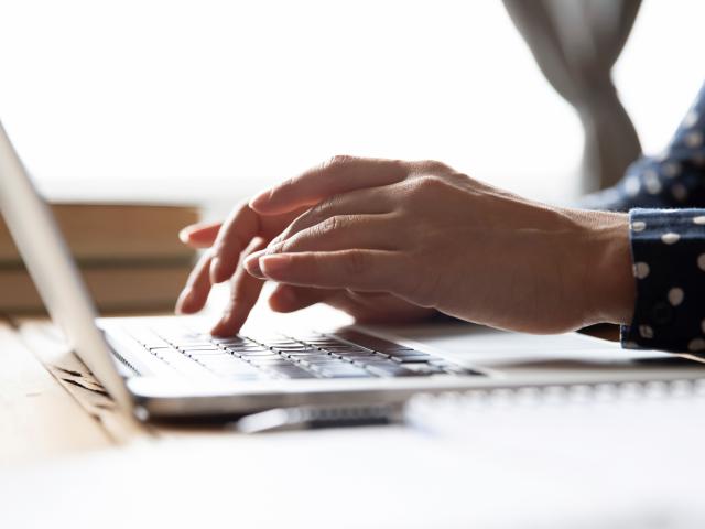 Woman completing funding application on laptop