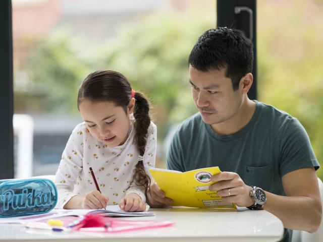 Father working with daughter on education at home