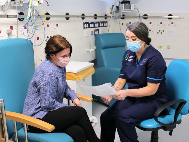 Anna Roynon wearing face mask chatting to a patient