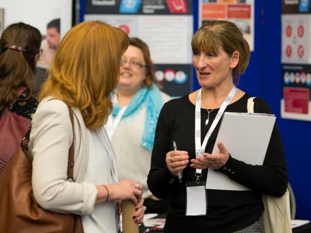 Two women talking with clipboard