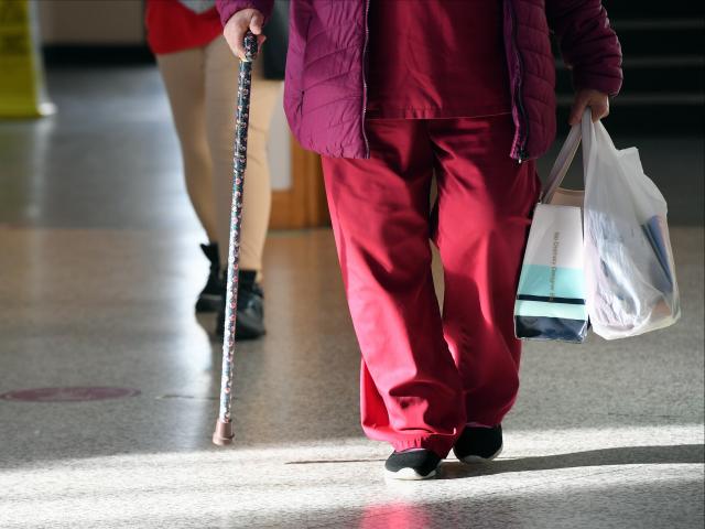 Woman with walking stick wearing scrubs