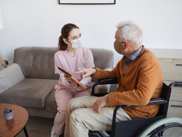 Care home worker speaking with elderly gentleman