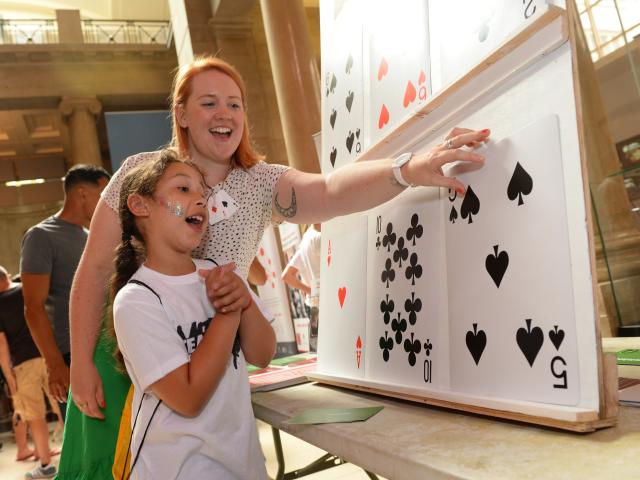 Child having doing a giant card game at event smiling