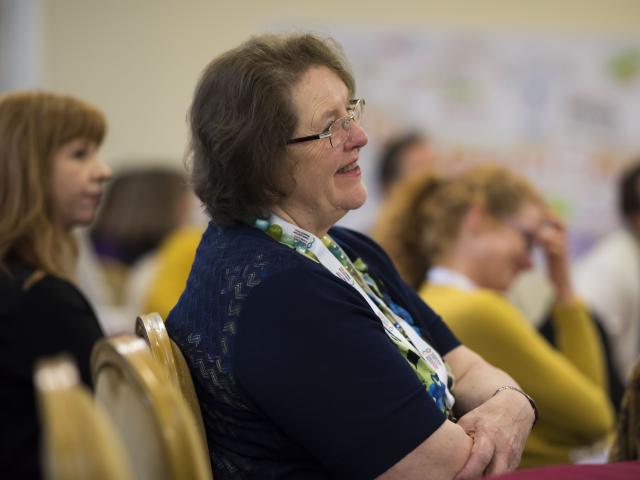 Woman smiling in the audience at an event