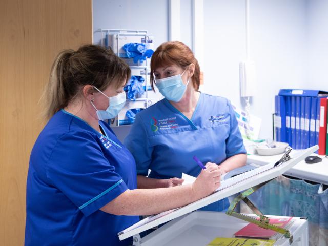 Two nurses looking at a patient chart