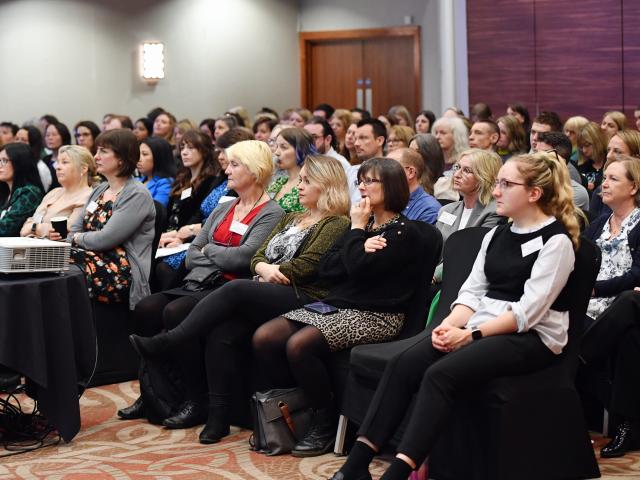 Llun o'r cynrychiolwyr yn eistedd yn y brif neuadd yn ystod yr araith agoriadol