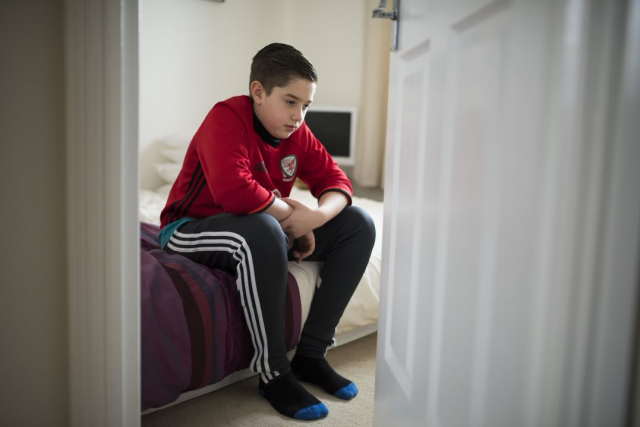 Young person sat alone in room