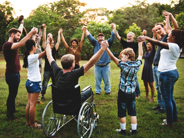 A group of people holding hands in the park.