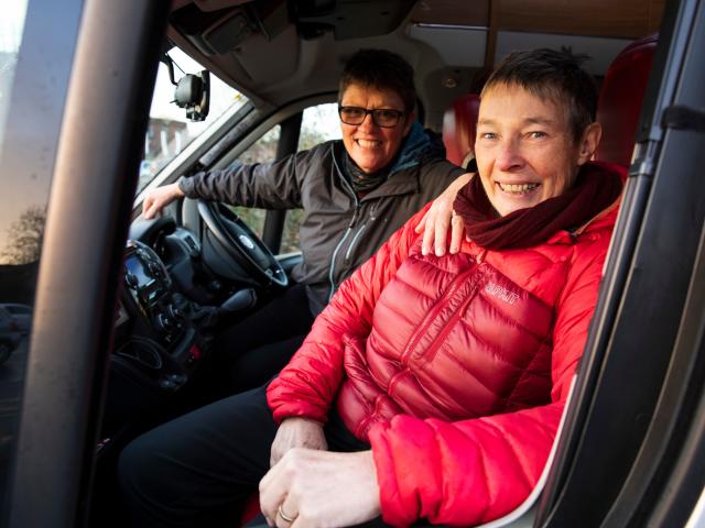 A couple of women sitting in a car. 