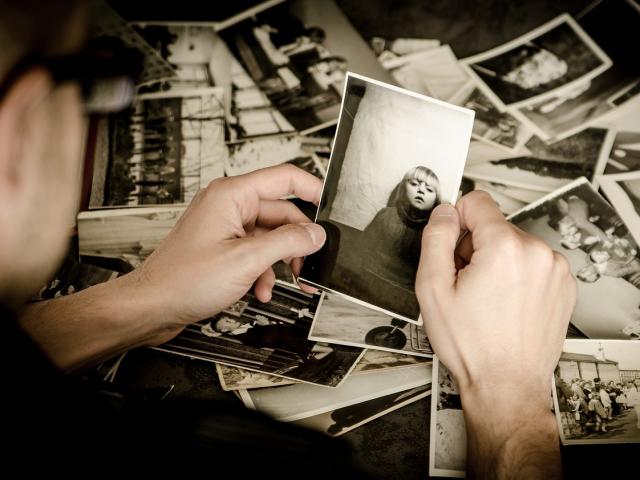 A person looking at an photo of themselves when they were young. 