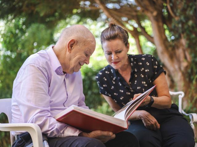 A woman caring for an elderly gentleman. 