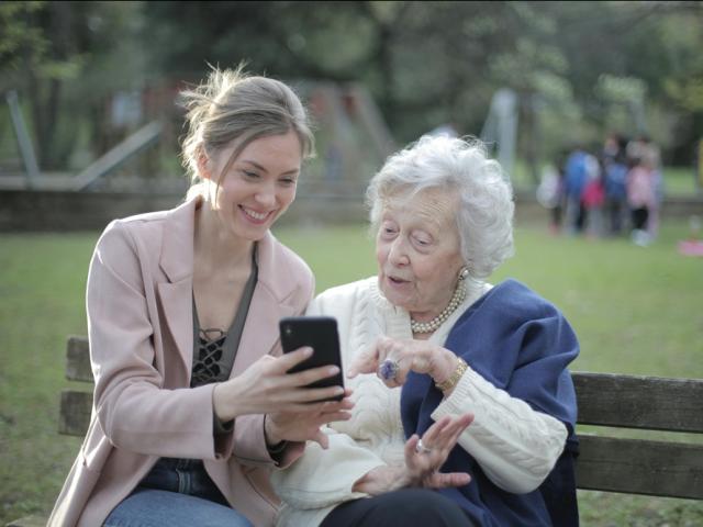 Mother and daughter talking on bench