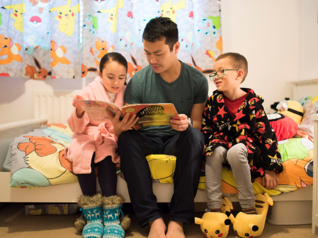 Dad reading a book to children