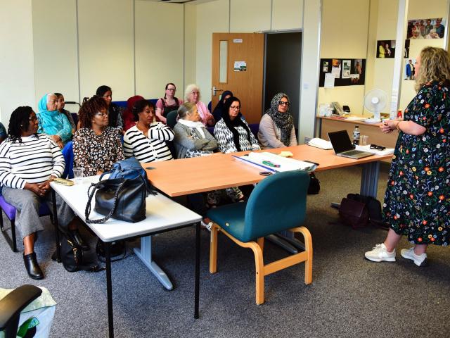 Diverse ethnicity and age range of people sat in a meeting