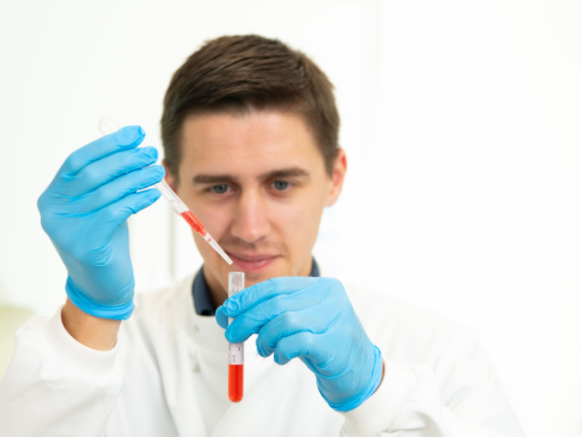 Man using a pipet to put liquid in a test tube