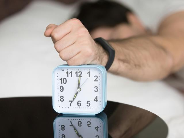a_man_snoozing_an_alarn_clock