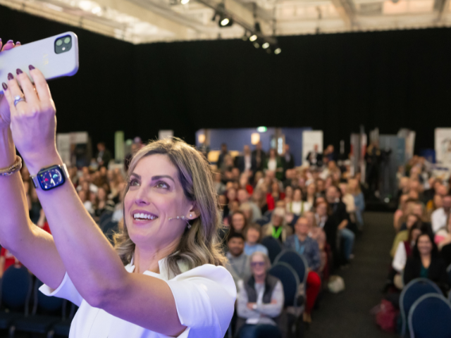 Andrea Byrne taking a selfie with the audience at the conference