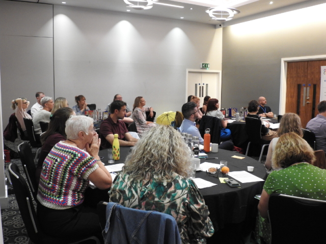A group of people sitting around a table a discussing research. 