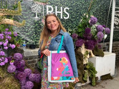 woman_posing_with_bag_against_green_backdrop