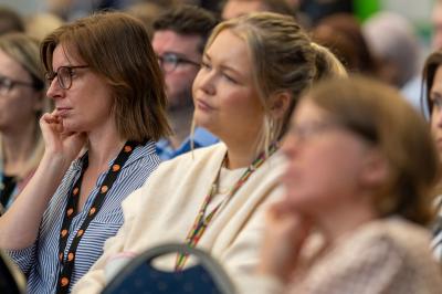 Two women watching people speak