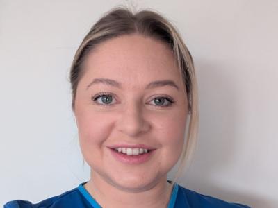 a_woman_in_blue_scrubs_smiling