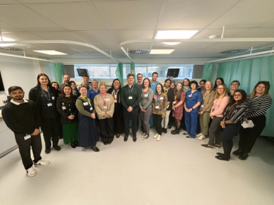 a_group_of_people_standing_together_for_a_photo_on_a_hospital_ward